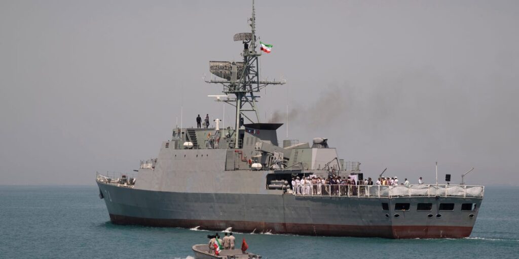 An Iranian frigate was seen capsizing at port while next to merchant ships, in another black mark for the country’s record of naval mishaps