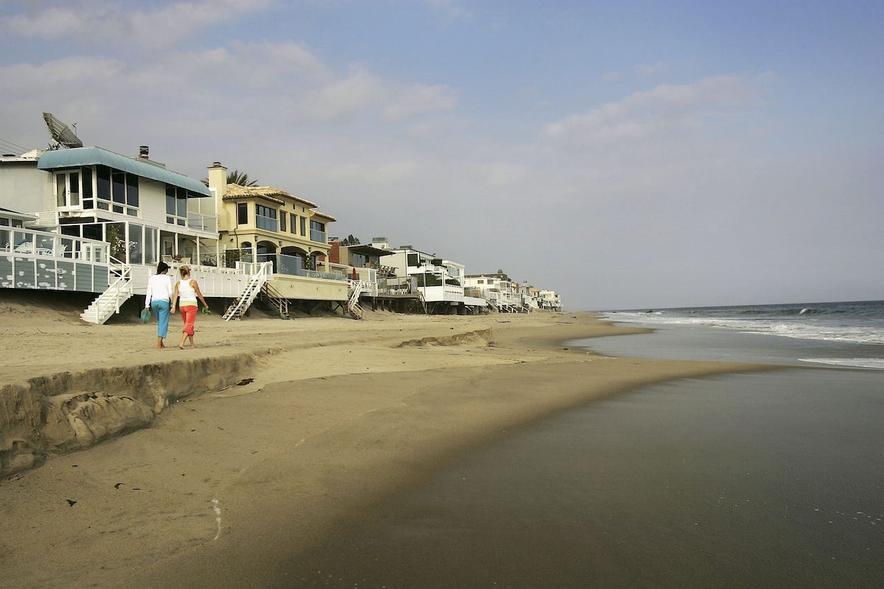 People walking along Carbon Beach in Malibu in 2005, which is lined by ocean-facing mansions.