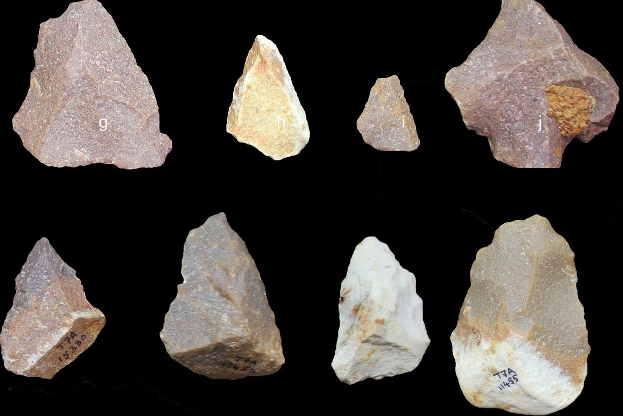 Prehistoric stone tools on a black background